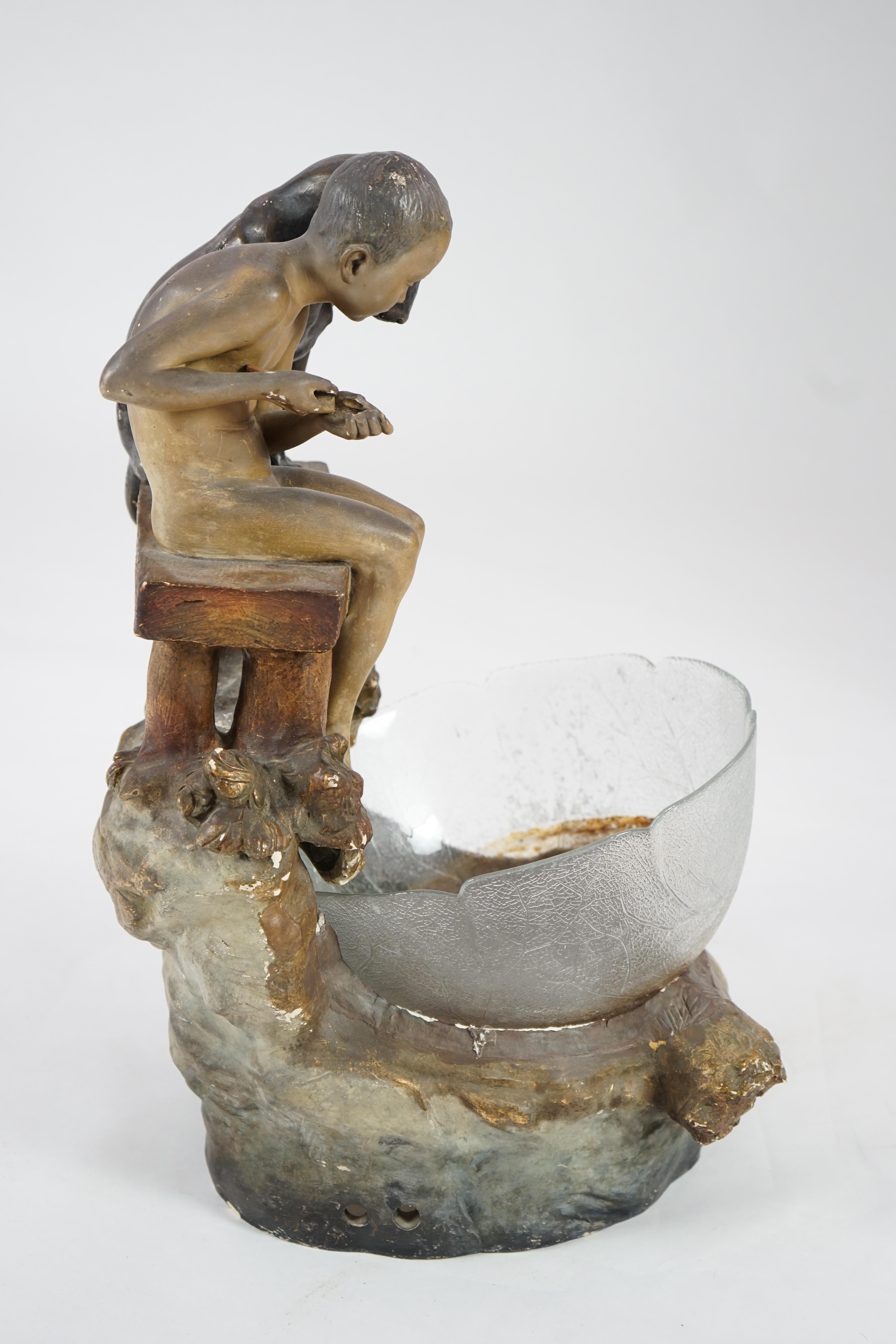 A Goldscheider group of a boy and a dog looking into a pool. Condition - fair, glass bowl not original